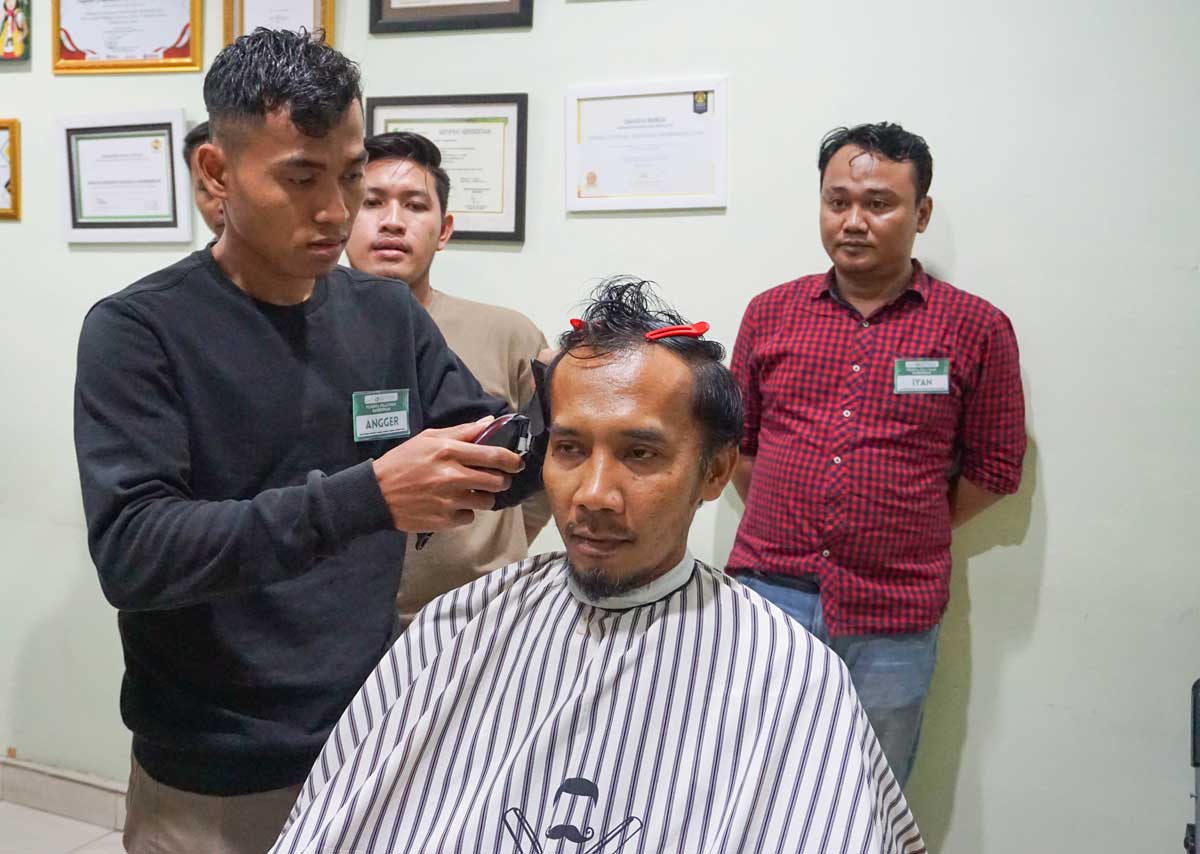 Participants complete hands-on barber training at YIIM